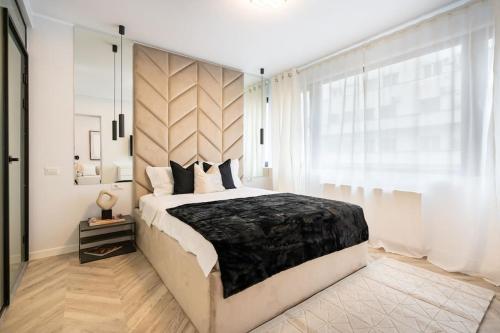um quarto com uma cama grande e uma janela grande em Mellow - Calea Victoriei - 2BR Luxury Apartment em Bucareste