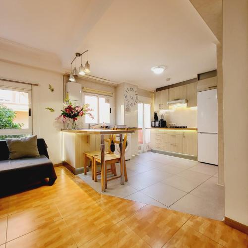 a kitchen and living room with a table and a couch at Pintor 31 in Valencia