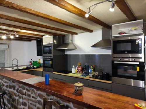 une grande cuisine avec un comptoir en bois dans l'établissement Maison à côté de la mer, à Flamanville