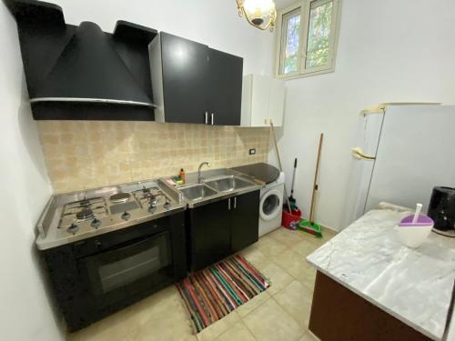 a kitchen with a stove and a sink and a microwave at Tempio di Giove Park in Siracusa