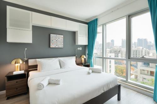 1 dormitorio con 1 cama grande y ventanas grandes en Fairways West Tower - 1BR Apartment - Allsopp&Allsopp, en Dubái