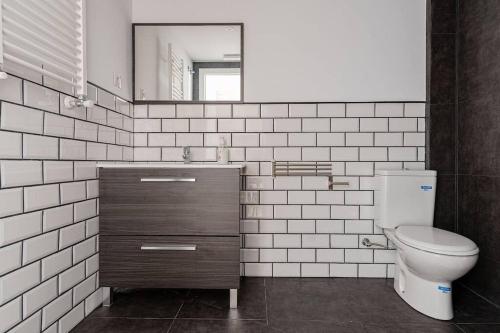 a bathroom with a toilet and a sink and a mirror at Charming and great 3 beds apartment in Tetuán by SharingCo in Madrid