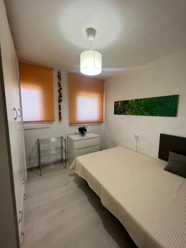 a small bedroom with two beds and a light at Costa Daurada Apartaments - COLON in Salou