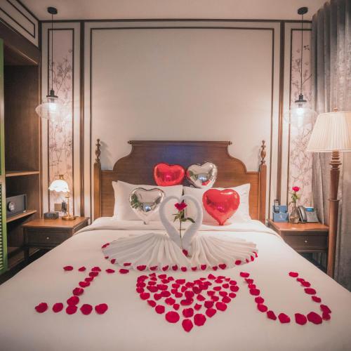 a bed with a bunch of red hearts on it at Regal Collection House in Dương Cảnh