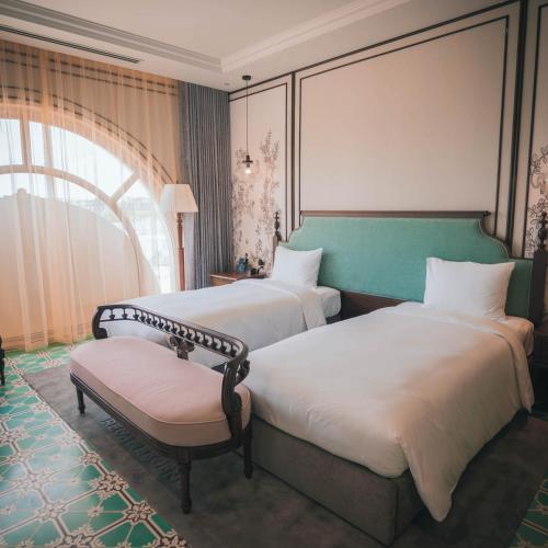 a hotel room with two beds and a window at Regal Collection House in Dương Cảnh