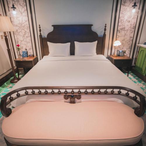 a bedroom with a large bed with white sheets and two tables at Regal Collection House in Dương Cảnh