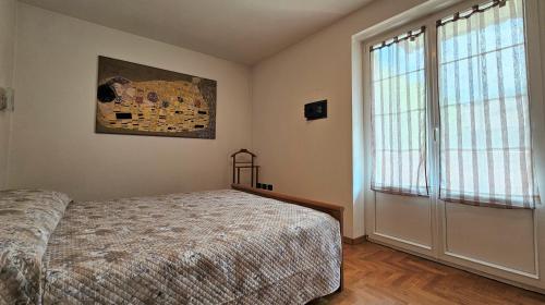 una camera con un letto e una grande finestra di TERRAZZA SUL LAGO a Molveno