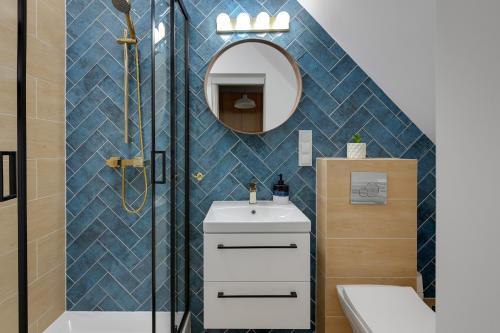 a bathroom with a shower and a sink and a mirror at Grand Apartments - Balticana Apartment in Sopot