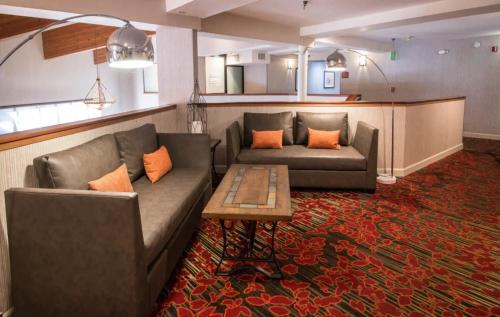 a living room with two couches and a table at Empeiria High Sierra Hotel in Mammoth Lakes