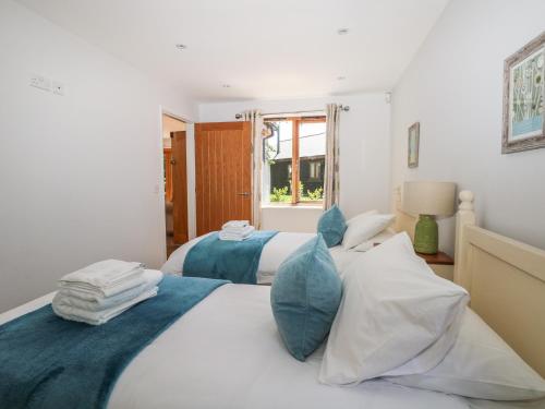 a white bedroom with two beds and a window at Badgers Sett in Fareham
