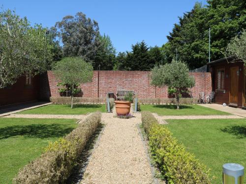 a garden with a brick wall and a large flower pot at Badgers Sett in Fareham