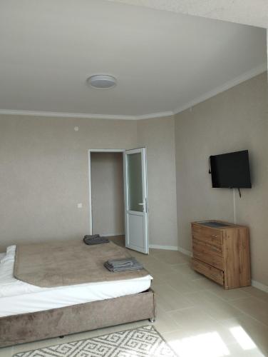 a bedroom with a bed and a flat screen tv at Готель Гармонія. Термально-оздоровчий комплекс. in Uzhhorod