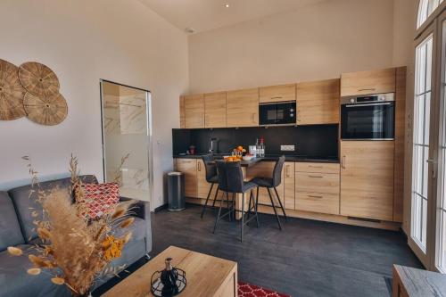 une cuisine et un salon avec un canapé et une table dans l'établissement Domaine Grand Piquecaillou - L'appartement Sauternes, à Saint-Maixant