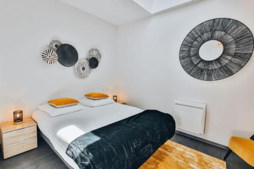 une chambre avec un grand lit et un miroir dans l'établissement Domaine Grand Piquecaillou - L'appartement Sauternes, à Saint-Maixant