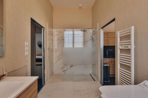une grande salle de bain avec douche et lavabo dans l'établissement Domaine Grand Piquecaillou - L'appartement Sauternes, à Saint-Maixant