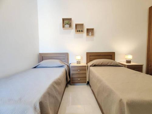 two beds sitting next to each other in a bedroom at Lorenza Letting Two in Marsaxlokk