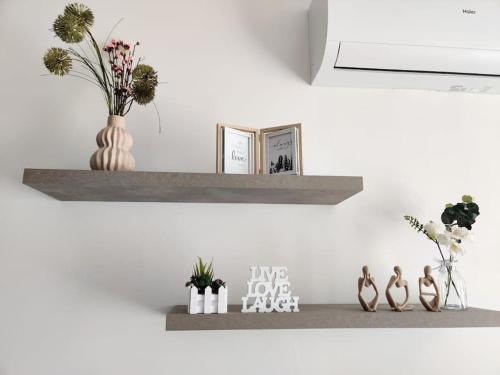 a shelf on a wall with flowers and vases at Lorenza Letting Two in Marsaxlokk