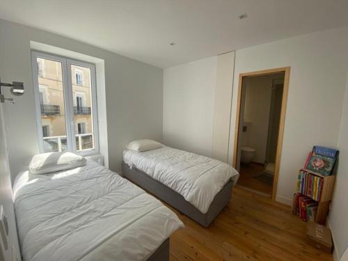 une chambre avec deux lits et une fenêtre dans l'établissement Luminueux T3 au cœur de Biarritz, proche plages et Halles ! - FR-1-239-973, à Biarritz