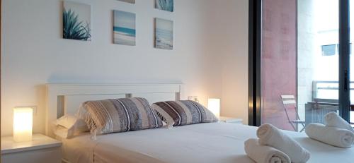 a white bed with two stuffed animals on top of it at Apartament Julia in L'Eucaliptus