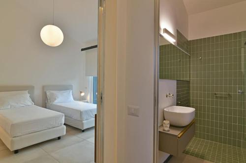 um quarto com uma cama e uma casa de banho com um lavatório em Modern Villa, pool + gym em Giarre