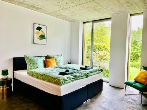 een slaapkamer met een bed en een groot raam bij Luxury Villa EMG Frankfurt Heidelberg - Bensheim in Bensheim