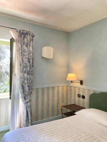 a hotel room with a bed and a window at Locanda Maison Verte in Cantalupa