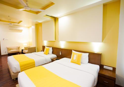a hotel room with two beds and a projector screen at BloomSuites I Electronics City in Bengaluru