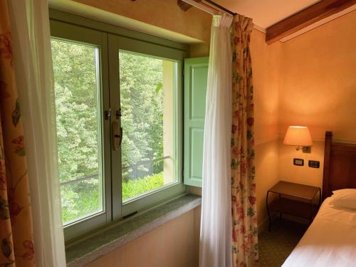 a bedroom with a window and a bed and a bed and a desk at Locanda Maison Verte in Cantalupa