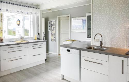 una cocina con armarios blancos y fregadero en Stunning Home In Kjerstad With Wifi, en Kjerstad