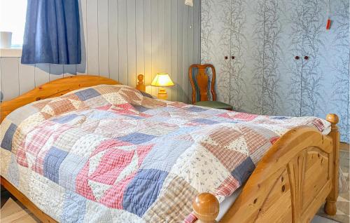 1 dormitorio con cama de madera y edredón en Stunning Home In Kjerstad With Wifi, en Kjerstad