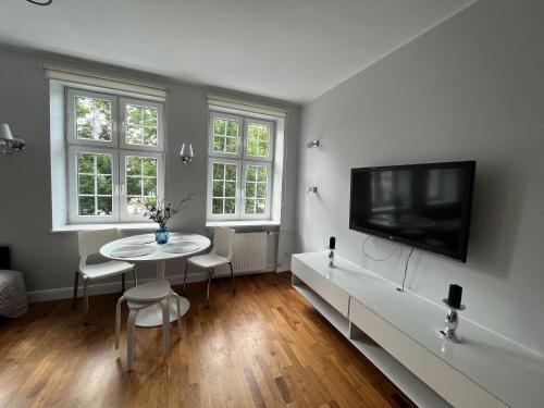 a living room with a table and a flat screen tv at Dom & House - Apartments Old Town Szeroka in Gdańsk