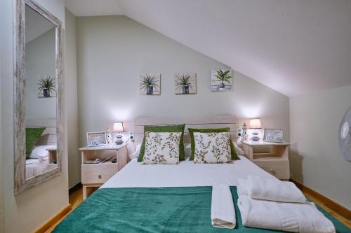 a bedroom with a large white bed with plants on the wall at Peregrina Pensión 2 in O Pedrouzo