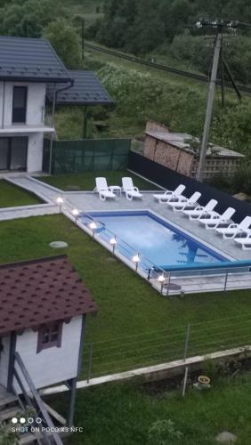 a swimming pool with lounge chairs next to a house at Фенікс in Yaremche