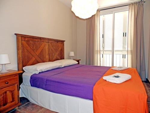a bedroom with a large bed and a window at Apartamentos Medano - Atico Playa in El Médano