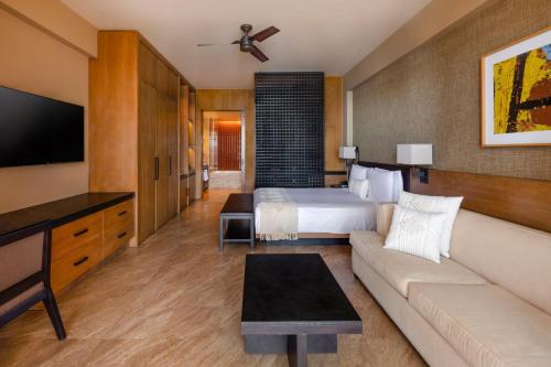 a hotel room with a bed and a couch at Casa Maat at JW Marriott Los Cabos Beach Resort & Spa in San José del Cabo