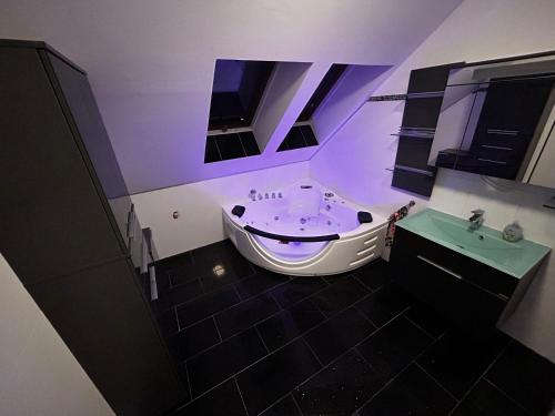 a bathroom with a white tub and a sink at Pension Günther in Graz