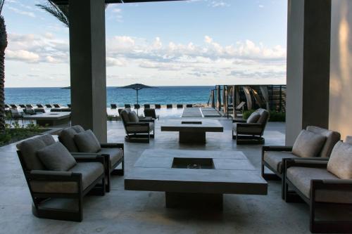 a living room with chairs and tables and the ocean at Casa Maat at JW Marriott Los Cabos Beach Resort & Spa in San José del Cabo
