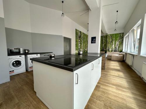 a kitchen with white cabinets and a black counter top at BLUE Hostel - Private Rooms by Friendly Hostel in Poznań