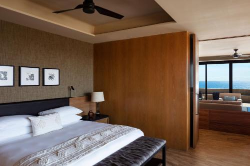a bedroom with a large bed and a living room at Casa Maat at JW Marriott Los Cabos Beach Resort & Spa in San José del Cabo