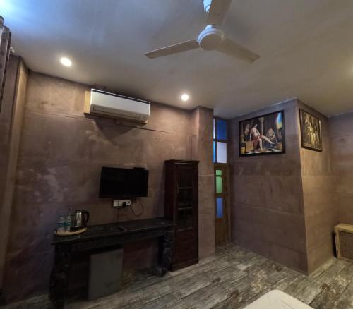 a living room with a ceiling fan and a television at Rani Mahal in Jodhpur