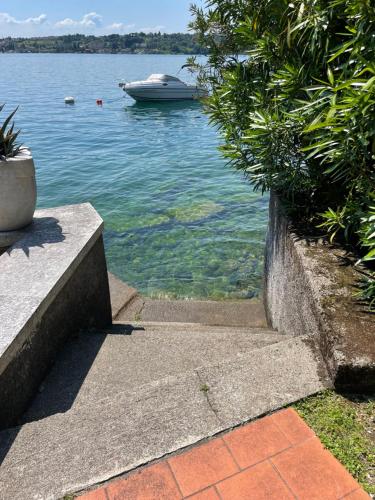a boat in the water next to a walkway at Lakefront holiday in Salò