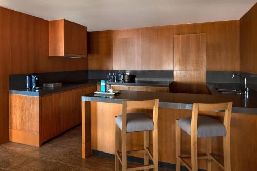 a kitchen with a bar with two stools at Casa Maat at JW Marriott Los Cabos Beach Resort & Spa in San José del Cabo