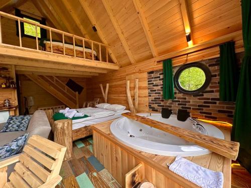 a large bathroom with a tub and a bed and a bedroom at Moon River Bungalow in Ayder Yaylasi