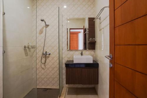 a bathroom with a shower and a sink and a mirror at Royal Majesty Villas Jimbaran in Jimbaran
