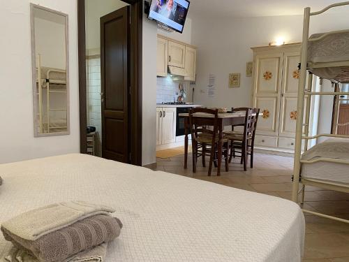 a bedroom with a bed and a kitchen with a table at Vistamare in Orosei