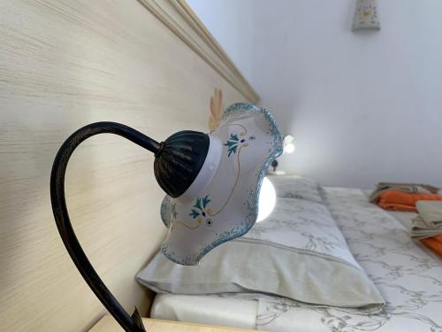 a lamp sitting on a wall next to a bed at Vistamare in Orosei