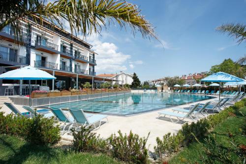 una piscina con tumbonas y un hotel en Kazdağları Allia Thermal Health & Spa en Edremit