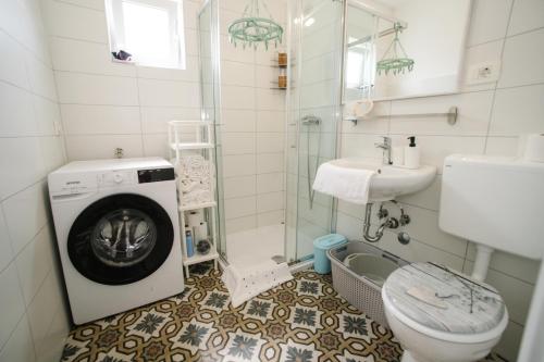 y baño con lavadora y lavamanos. en Sunny Apartment for 2, en Murter