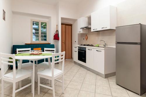 eine Küche mit einem Tisch und Stühlen sowie einem Kühlschrank in der Unterkunft Casa Vacanza Nibbio 26 in Sperlonga