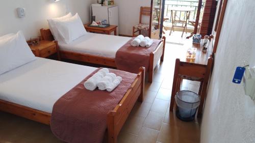 um quarto de hotel com duas camas com toalhas em Loggia em Agia Galini